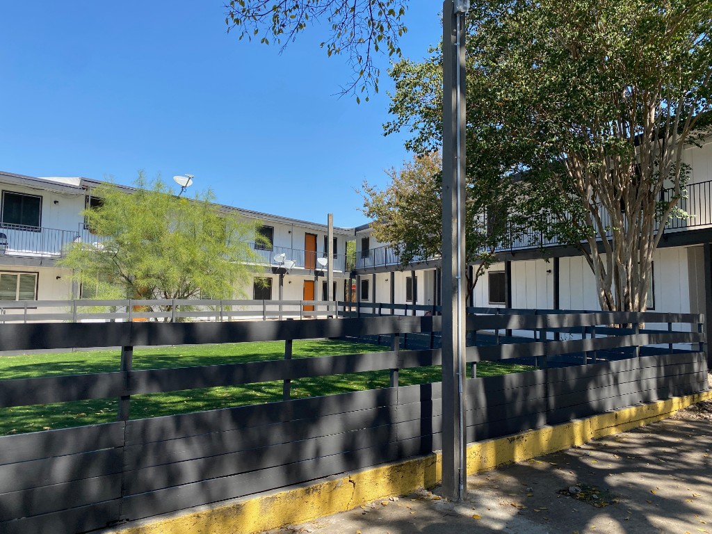 Updated multifamily property exterior and fencing with clean paint finish